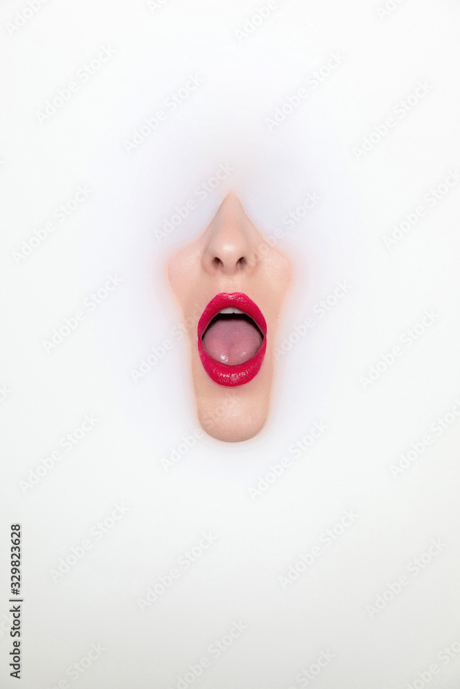 Gesicht im Milchbad mit roten Lippen 