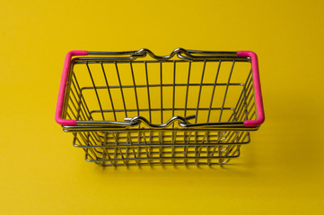 Shopping basket on a yellow background. Supermarket food price concept.