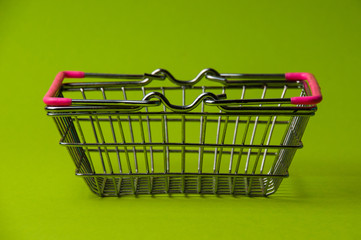 Wall Mural - Shopping basket on a green background. Supermarket food price concept, holiday discounts