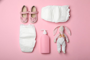 Wall Mural - diapers and baby accessories on pink background, flat lay