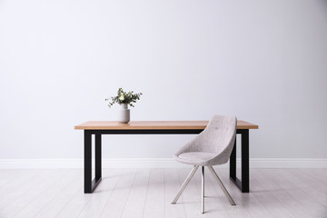 Sticker - Table and chair near white wall in room. Stylish interior design