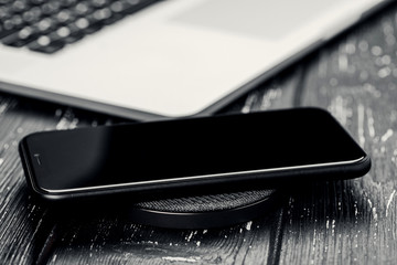 close-up phone charging on wireless charger device.