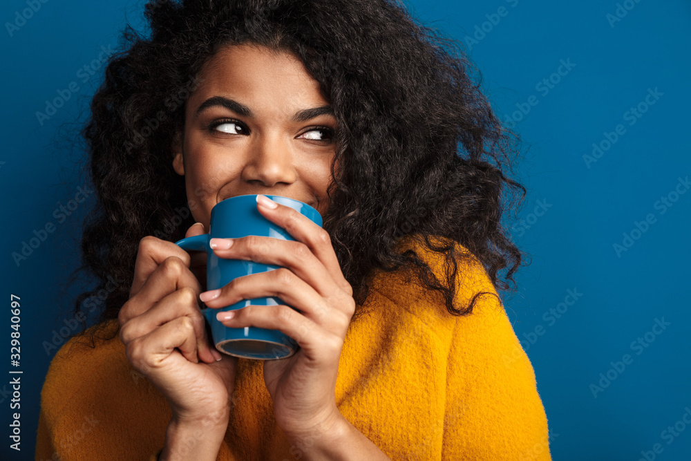 African woman posing isolated over blue wall - obrazy, fototapety, plakaty 