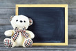 © izzzy71 - Teddy bear with blank blackboard on wooden background