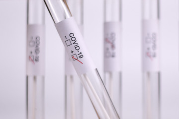 Wall Mural - positive medical test tube sample for coronavirus with label covid-19 with other blury tubes in back