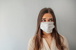 Woman wear with protective face mask. Young woman with face mask. Face of a mask-wearing woman with fear in the eye. Beautiful young woman wearing contamination mask at home