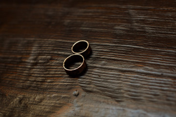 two gold  wedding rings on a wooden background close up portrait with copy space for text. wedding details. wedding day. wedding background