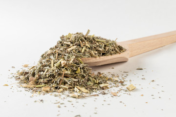 wormwood herb or in latin Absinthii herba herb in wooden spoon isolated on white background. medicinal healing herbs. herbal medicine. alternative medicine