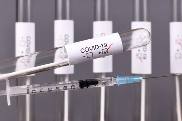 Wall Mural - medical test tube sample for coronavirus with covid-19 label with positive test result and syringe, 