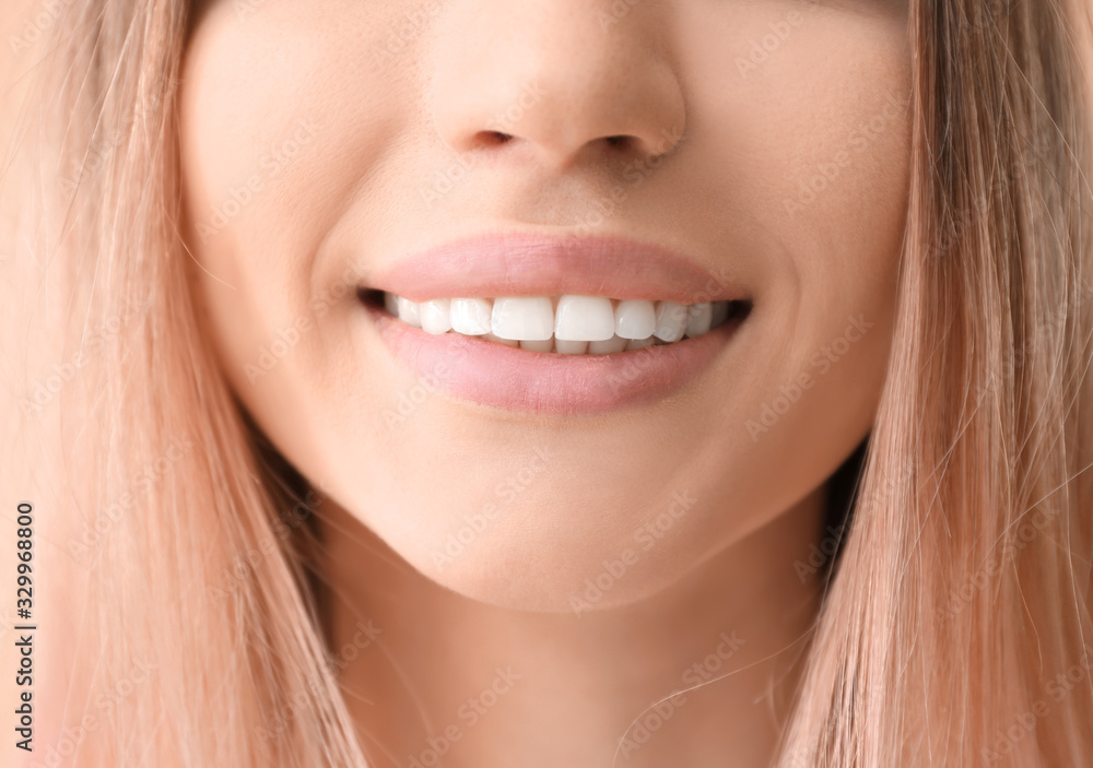 Young woman with healthy teeth on color background, closeup