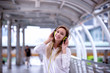 Portrait Of Smiling Young Woman Listening Music On Headphones While Standing Outdoors