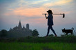 © ID_Anuphon - silhouette of farmer walks carry hoe to the rice fiels in the early morning, living life of Thai culture traditional life in Countryside, with temple pagoda in background
