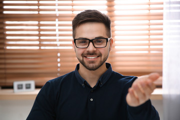 Wall Mural - Happy man using video chat in modern office, view from web camera