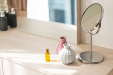 Dressing Table With Circle Mirror, Small Flower Vase In Glossy Ceramic White And Pink Vase And Reagent Bottle On The Wooden Counter For Everyday Skin Care And Cosmetic.