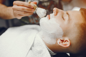 Wall Mural - A man in a barbershop. Clipping beard in the barber. Rest in hairdressing salon