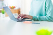 © TheSupporter - Close up of female hands typing on a laptop in a domestic environment