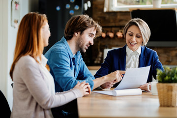 Wall Mural - Financial advisor and young couple going through lease agreement on a meeting.