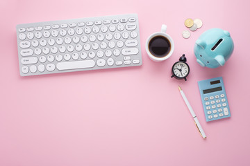 Wall Mural - Piggy bank, keyboard, clock, calculator and coins on pink desk