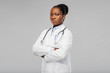 medicine, profession and healthcare concept - african american female doctor in white coat with crossed hands and stethoscope over background