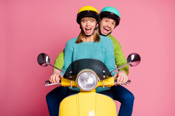 Photo of funny lady guy couple driving sitting big speed vintage yellow moped spend vacation together open mouth wear casual jumper colorful headgear isolated pink color background