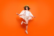 © deagreez - Full length photo of funny lady summer time jumping high enjoy great resort views wear stylish sun hat specs stylish white lace beach cape shorts isolated orange background