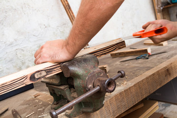 Male carpenter working on old wood in a retro vintage workshop.