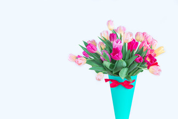  Beautiful bright bouquet of tulips in a blue paper vase isolated on a white background. Best gift for a woman on March 8, mother's Day. Mock up. Copy space