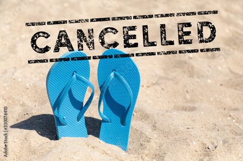 Fotografía flip flops in the sand and text cancelled - vacation cancel