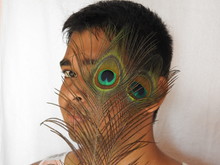 Close-up Portrait Of Man With Eye Covered By Peacock Feathers
