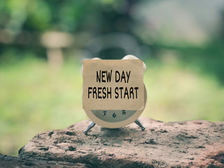 Motivational and inspirational wording. New Day Fresh Start written on a paper. Vintage styled background.