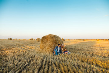 Wall Mural - Happy family with bread and buns in dry grass field.