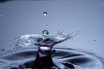 Wall Mural - water drops collision on a blue background. abstract clear nature background