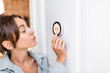 © rh2010 - Woman regulating heating temperature with a modern wireless thermostat installed on the white wall at home. Smart home heating regulation concept