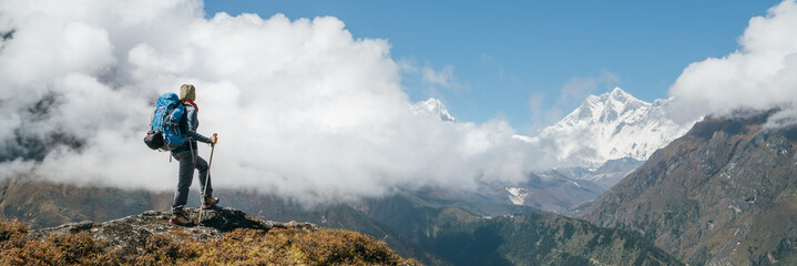 young hiker backpacker woman using trekking poles enjoying the nuptse 7861m mountain during high alt