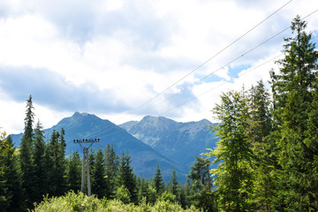 High voltage electric power transmission line somewhere in the forest in mountains