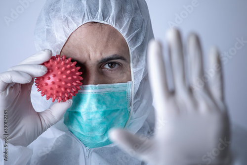 Cuadros en Lienzo Ricercatore con tuta protettiva guanti e mascherinai dice stop al coronavirus -