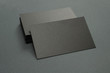 © Yurii - stack of black blank textured business cards on dark paper background, us size 3.5 x 2 inches, as template for design presentation.