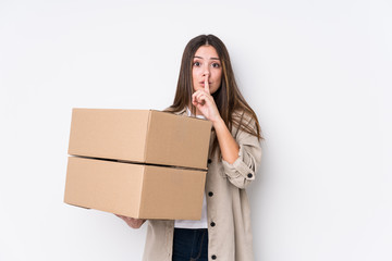 Wall Mural - Young caucasian woman moving to a new home keeping a secret or asking for silence.