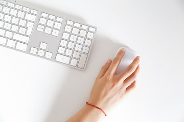 Office desk table with keyboard,hand holding mouse Top view