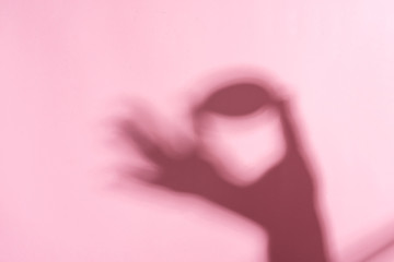 Wall Mural - Creative background from shadows of woman's hand with Easter egg against a pastel pink background.