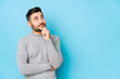© Asier - Young caucasian man against a blue background isolated looking sideways with doubtful and skeptical expression.