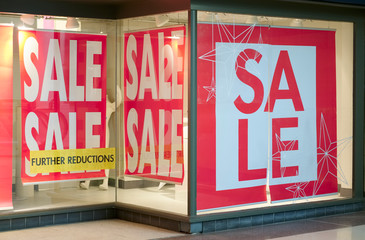 Closing down sale sign with further reductions and discount in shop store mall window