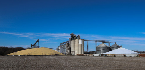 grain elevator along the hoosier haertland highway with two giant outside storage piles of corn, one