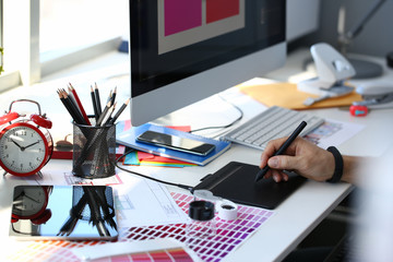 Designer male arm hold graphic pad pen working on project at home computer closeup background