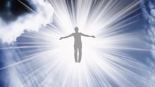 Creative 4k Video With The Parallax Effect Of The Sky With Moving Clouds And Sunlight, The Silhouette Of A Man With Spread Arms, Flying In Bright Light And Dissolving In It. The Concept Of Open Mind.