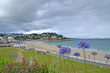 Wall Mural - Beautiful empty beach in Brittany with traditional houses and flowers in foreground