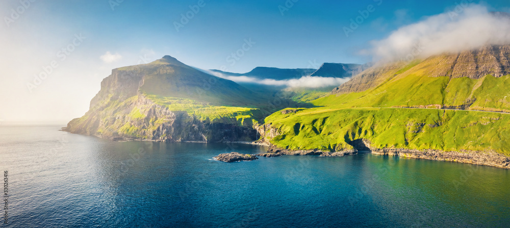 View from flying drone. Misty morning scene of Vagar island. Colorful summer scene of Faroe Islands, Kingdom of Denmark, Europe. Traveling concept background - obrazy, fototapety, plakaty 