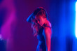 Sensual beauty fashion attractive young beautiful blond hair 20s girl model stand at purple studio background. Sexy trendy stylish millennial woman posing in neon violet party night light concept.