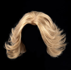 Blonde hair wig on black background