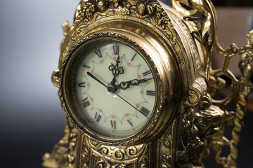 dial of vintage bronze clock, antique clock photo close up, old bronze clock in gilding, front of bronze fireplace clock,